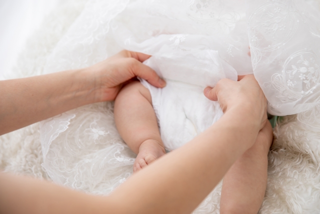 おむつ替えをするママの腕