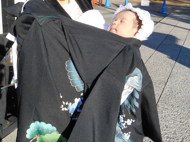 黒の産着が掛けられた赤ちゃん